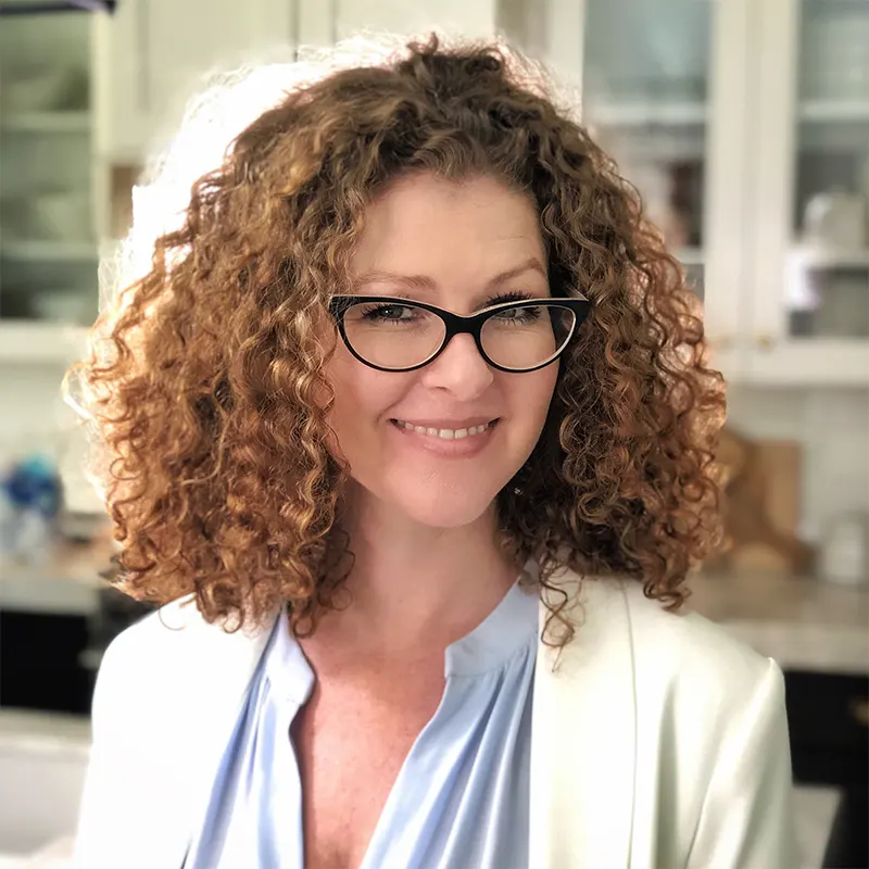 Advisory Council Member, Robin Afinowich. A white woman with curly red hair, wearing glasses and a blue shirt and white jacket